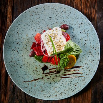 Fresh Greek salad in a bowl, top view