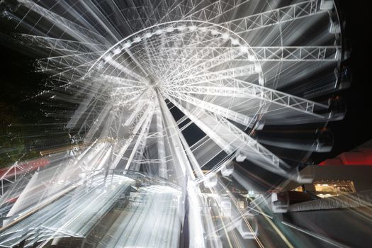 Abstract motion and zoom blur of rotatinmg ferris wheel at night on Brisbane South Bank Australia