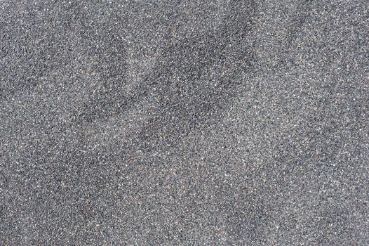 Dry black volcanic sand from Santorini texture background