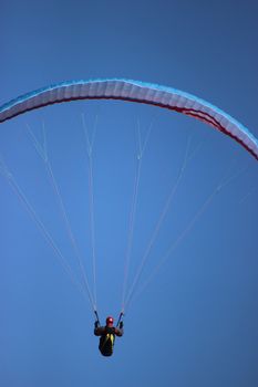 Paraglider Flying On Clear Blue Sky Background