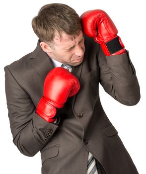 Businessman with boxing gloves defending against white background, close up view