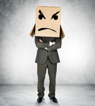 Depressed man with box over head with crossed arms