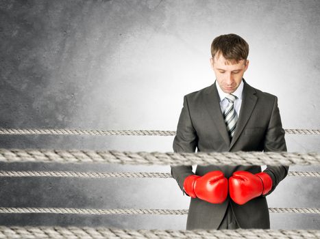 Businessman with boxing gloves on boxing ring