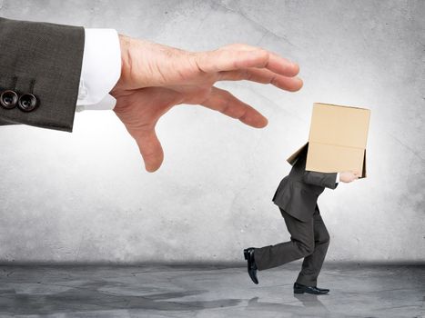 Business boss hand catching employee with box on his head