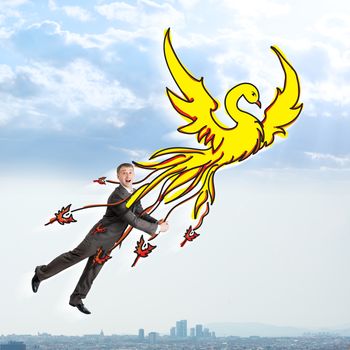 Surprised businessman flying on drawn firebird in sky