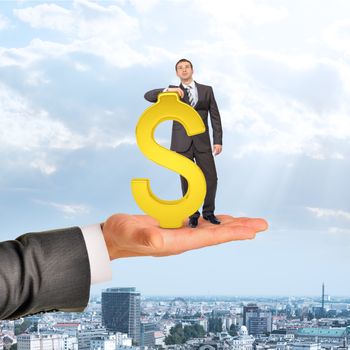 Businessman with dollar sign on big hand over city background