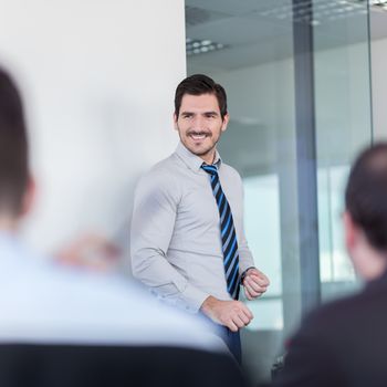 Relaxed cheerful team leader and business owner leading informal in-house business meeting. Business and entrepreneurship concept.