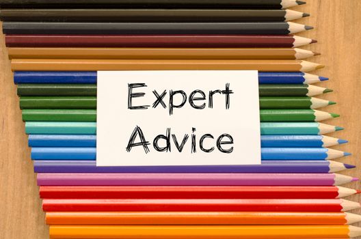 Expert advice text concept and colored pencil on wooden background