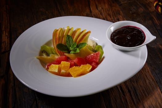 Healthy salad made of fresh fruitsin a white plate with sauce