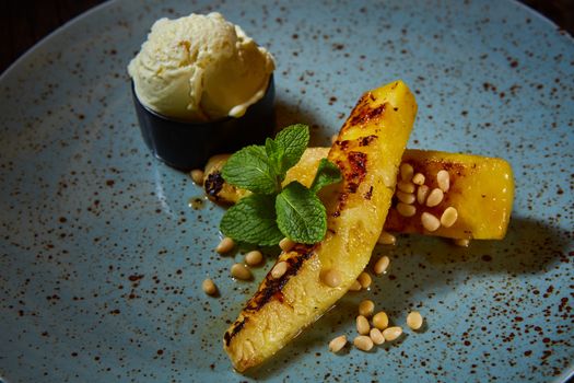 Grilled pineapple with ice cream and pine nuts