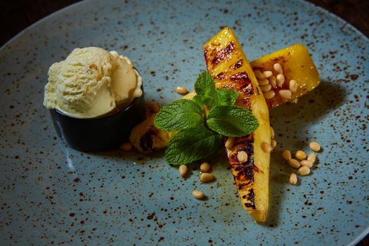 Grilled pineapple with ice cream and pine nuts