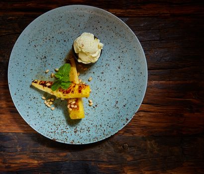 Grilled pineapple with ice cream and pine nuts