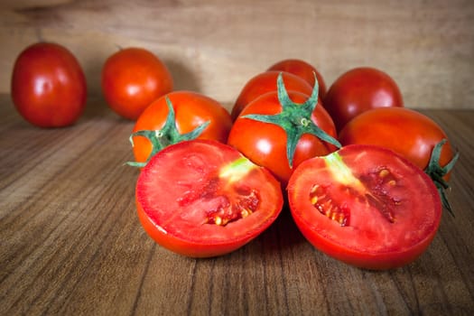 Close-up fresh ripe tomatoes on wood background .