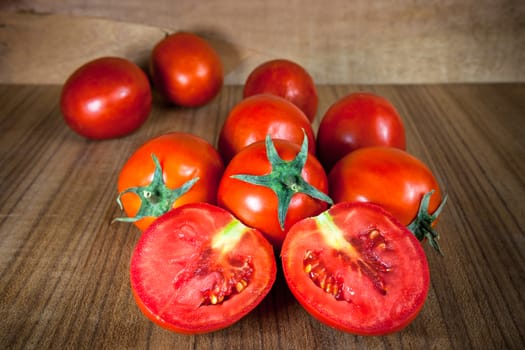 Close-up fresh ripe tomatoes on wood background .