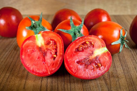 Close-up fresh ripe tomatoes on wood background .