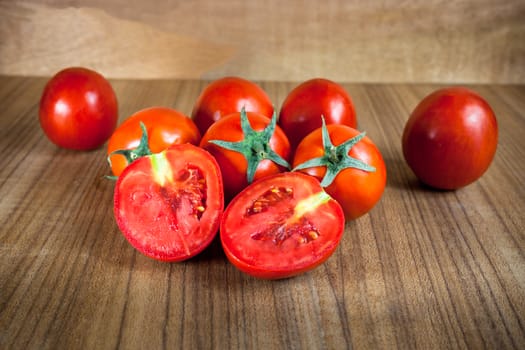 Close-up fresh ripe tomatoes on wood background .