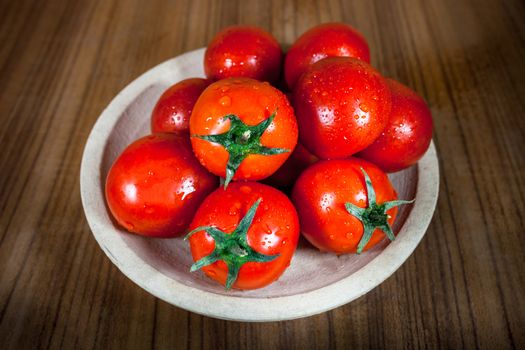 Close-up fresh ripe tomatoes on wood background .