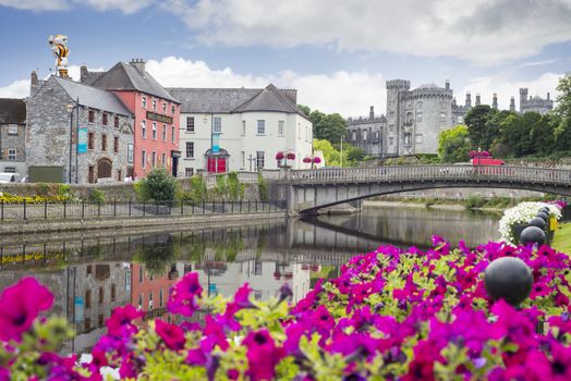 beautiful flower lined riverside view of kilkenny castle town and bridge