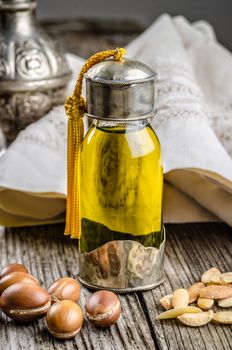 Bottle of argan oil with nuts and seeds.