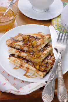 Pancakes sliced apples with caramel and chocolate for breakfast