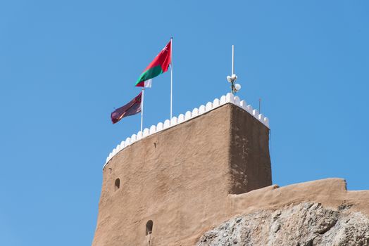 Detail of the medieval Fort Al-Mirani in Muscat, The Sultanate of Oman. The Omani flag in the foreground.