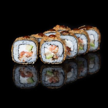 Grilled sushi rolls with fish and sause on  black background