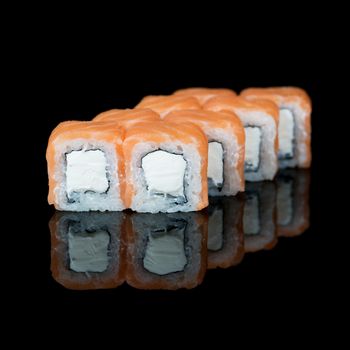 Sushi rolls with salmon and soft cheese on  black background