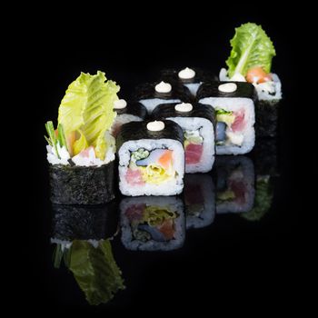 Sushi rolls with tuna and salmon on  black background