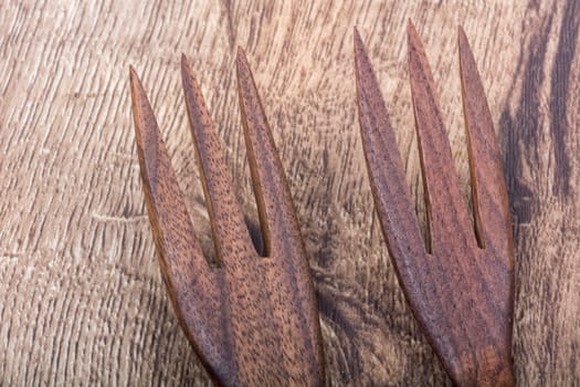 Wooden forks on a brown wooden background