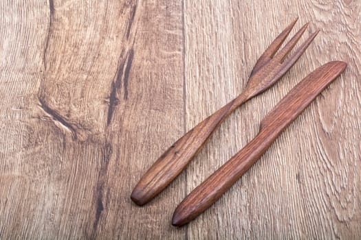 Wooden cutlery on a brown wooden background background