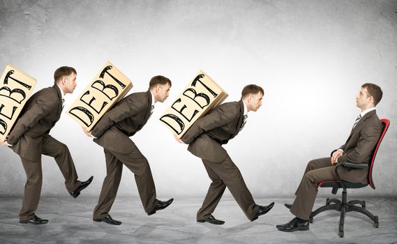 Businessmen carry boxes with word debt to boss
