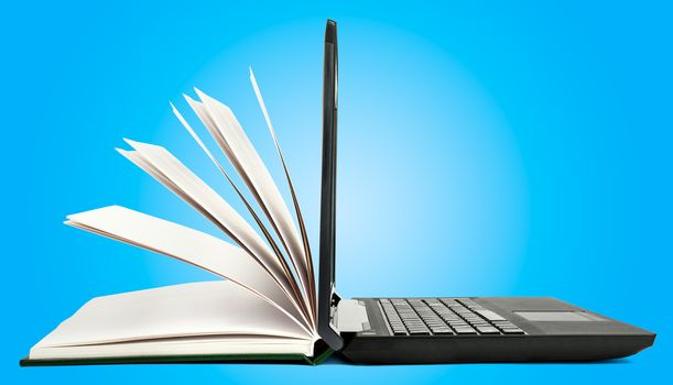 Book and open laptop on blue background