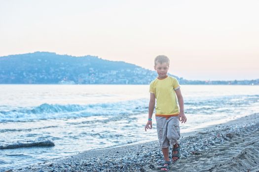 Kid boy walking at Alania beach, Turkey