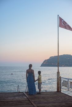 mother and son on the pier in the evening at Alania, Turkey