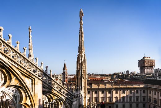 White marble statues on the roof of famous Cathedral Duomo di Milano on piazza in Milan, Italy 