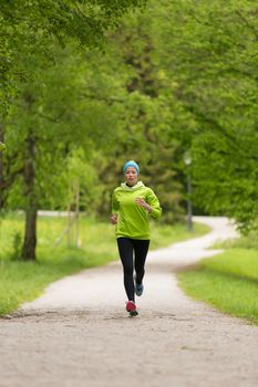 Sporty young female runner in city park.  Running woman. Female runner during outdoor workout in nature. Fitness model outdoors. Weight Loss. Healthy lifestyle. 