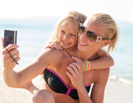 Mother and daughter selfie photographed at the beach