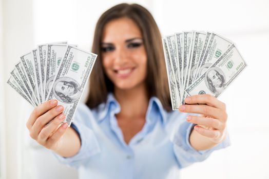 Happy successful Businesswoman in the office holding money. Focus on the money.