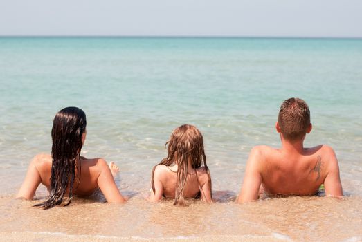 Family of three relaxing at beach