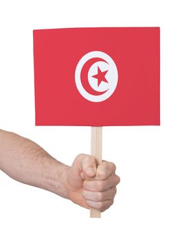 Hand holding small card, isolated on white - Flag of Tunisia