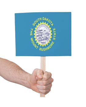 Hand holding small card, isolated on white - Flag of South Dakota