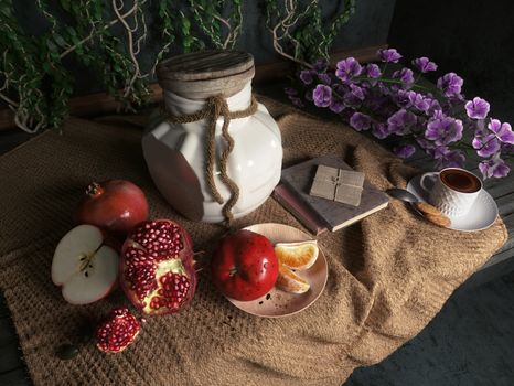 jar,apples,pomegranate,coffe cup with books and orange on canvas drapery conceptual still-life