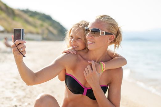 Mother and daughter selfie photographed at the beach