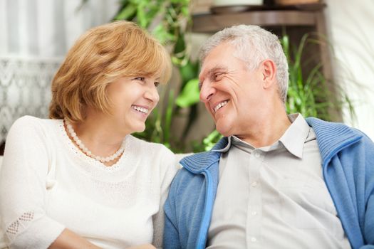 Happy senior couple in love sitting in living room