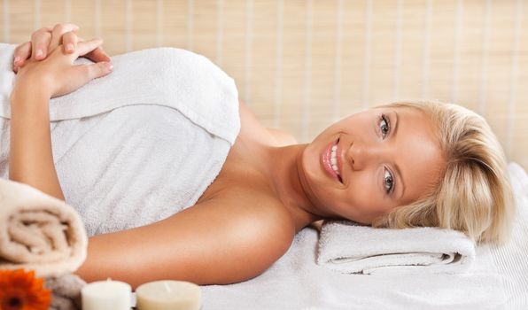 Young beautiful woman relaxing and enjoying at the spa center