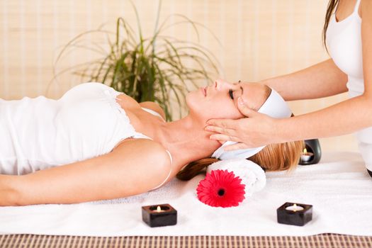 Young beautiful woman receiving head massage at the spa center