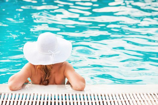 Young beautiful woman enjoying the sun in the pool
