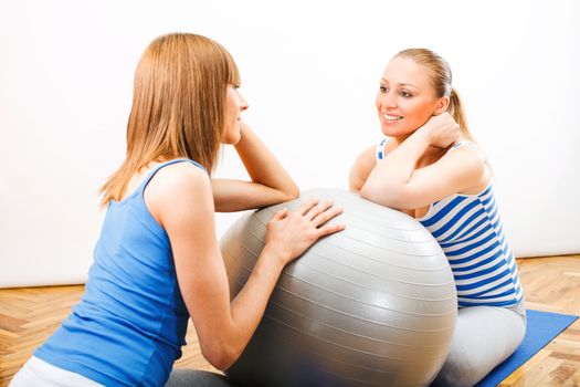 Fitness woman sitting on exercise mat and consult with Personal Trainer about training