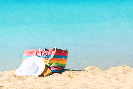 Multi Colored bag and white hat on the beach