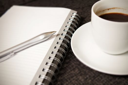 Coffee cup, notebook and pen